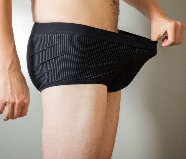 a man looks into his underpants after penis enlargement surgery